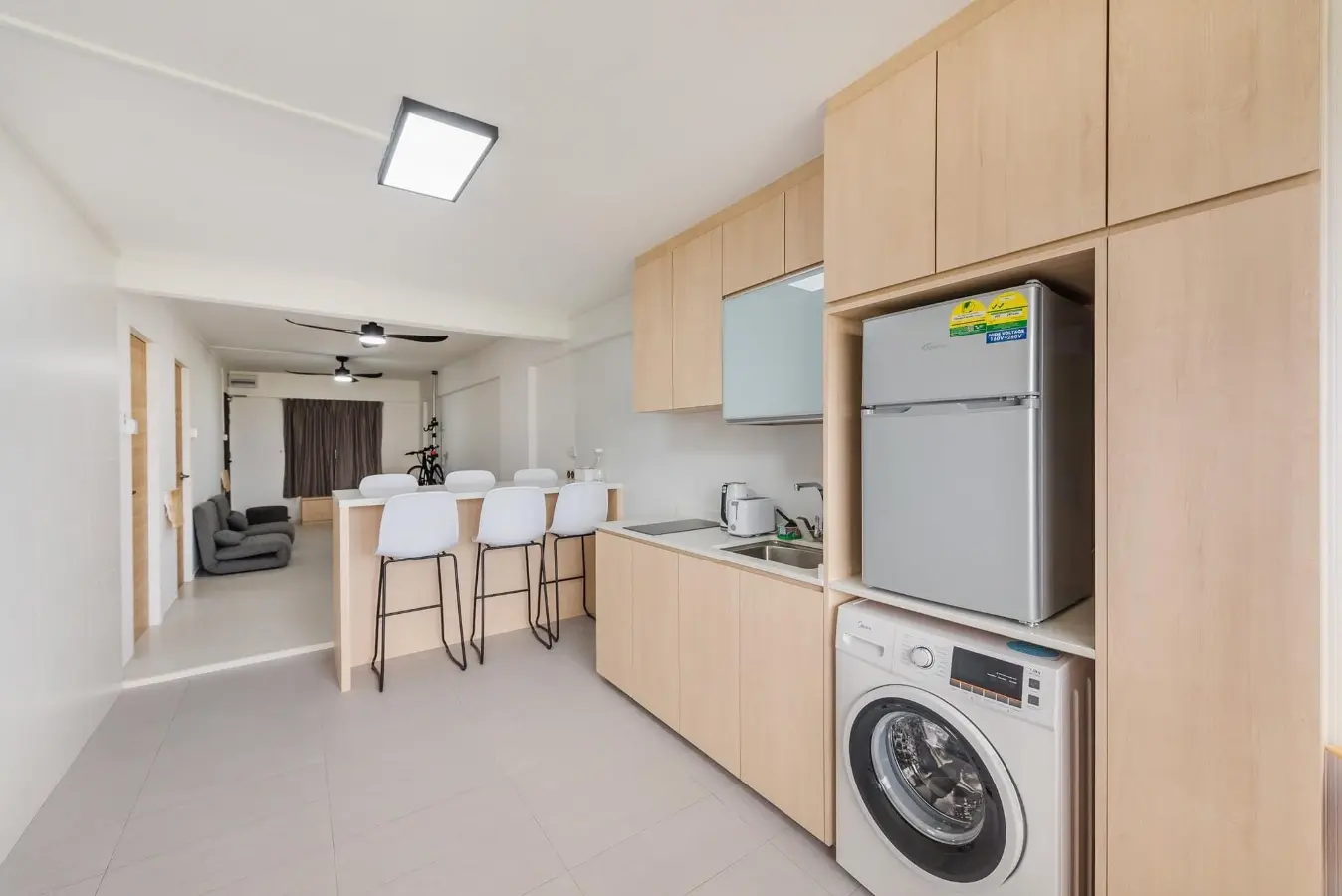 Pale oak kitchen and utility cabinetry in an open-plan home