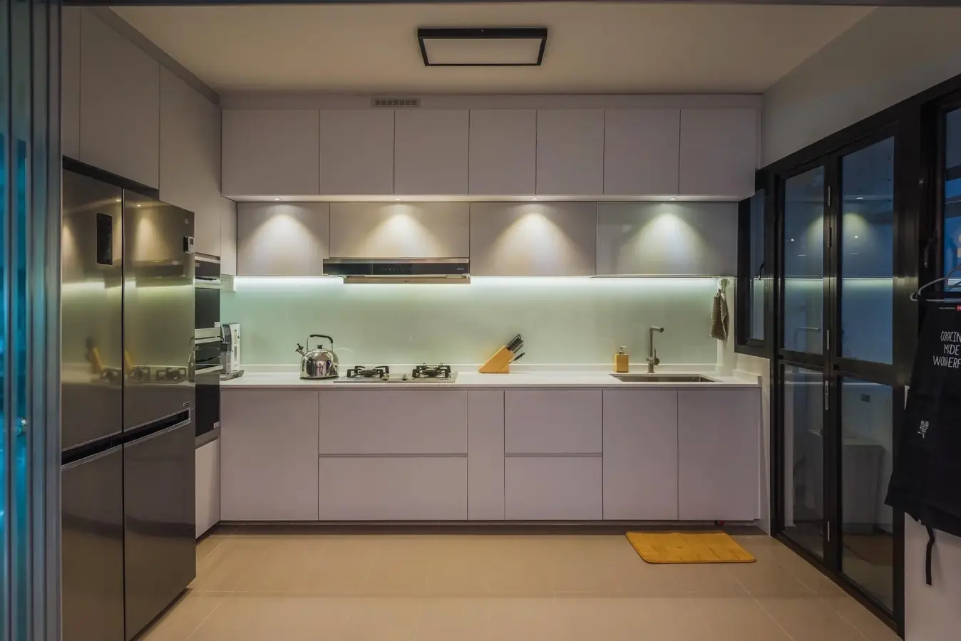 Handleless white kitchen cabinetry with integrated lighting