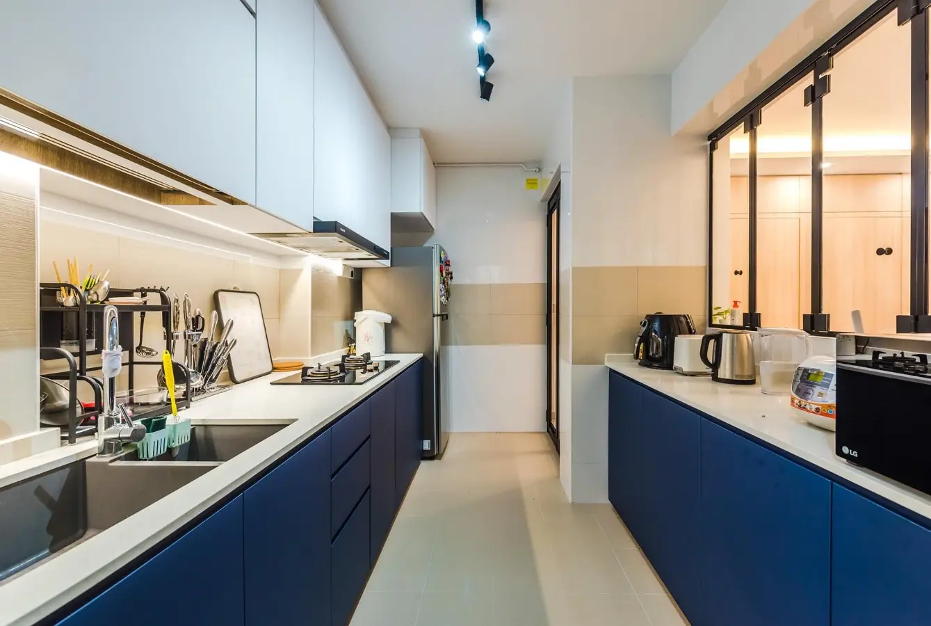 Blue galley kitchen cabinets with white countertops