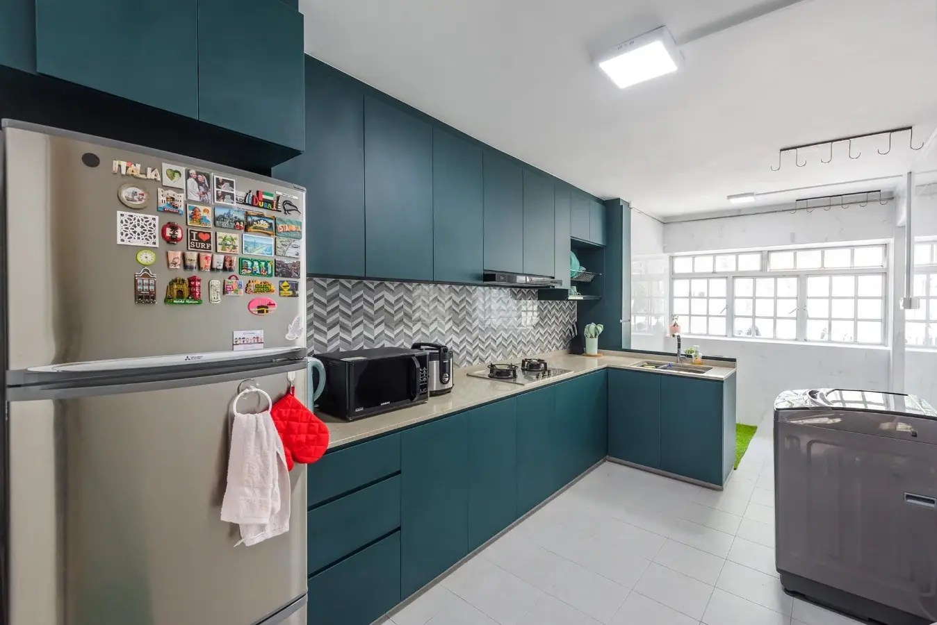 Teal kitchen cabinetry with patterned backsplash