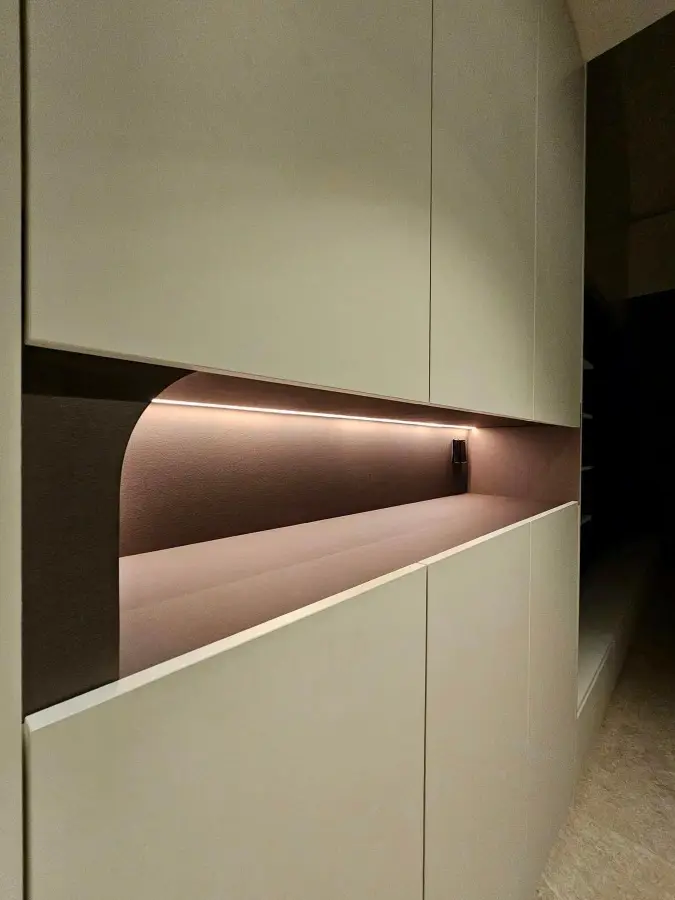 Custom built-in carpentry with a recessed shelf and warm integrated LED lighting