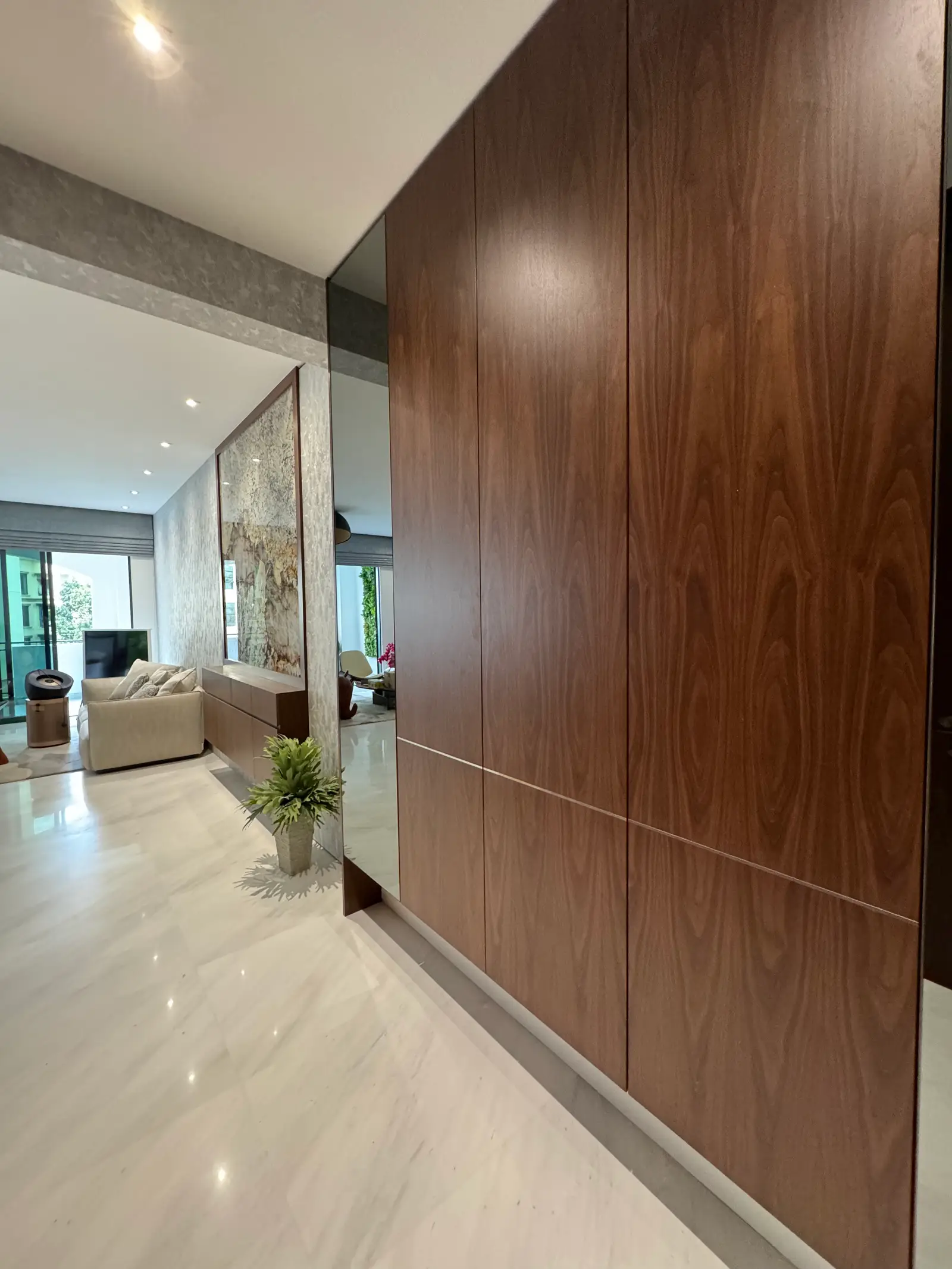 Full-height walnut hallway storage and mirrored wall panels