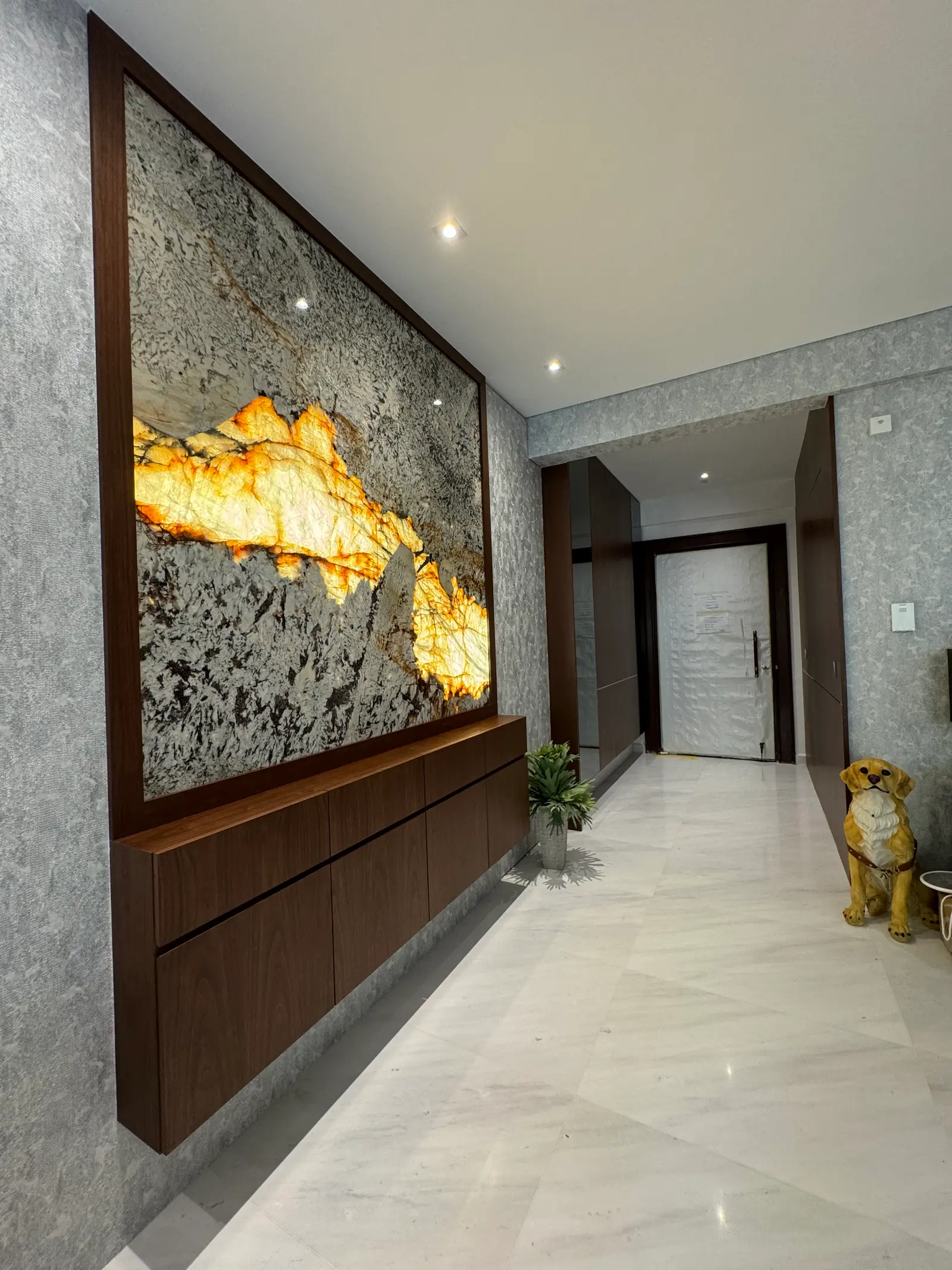 Backlit stone feature wall with floating walnut console