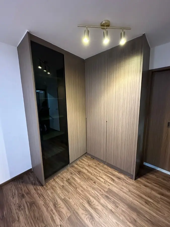 Custom corner wardrobe with woodgrain and dark glass doors